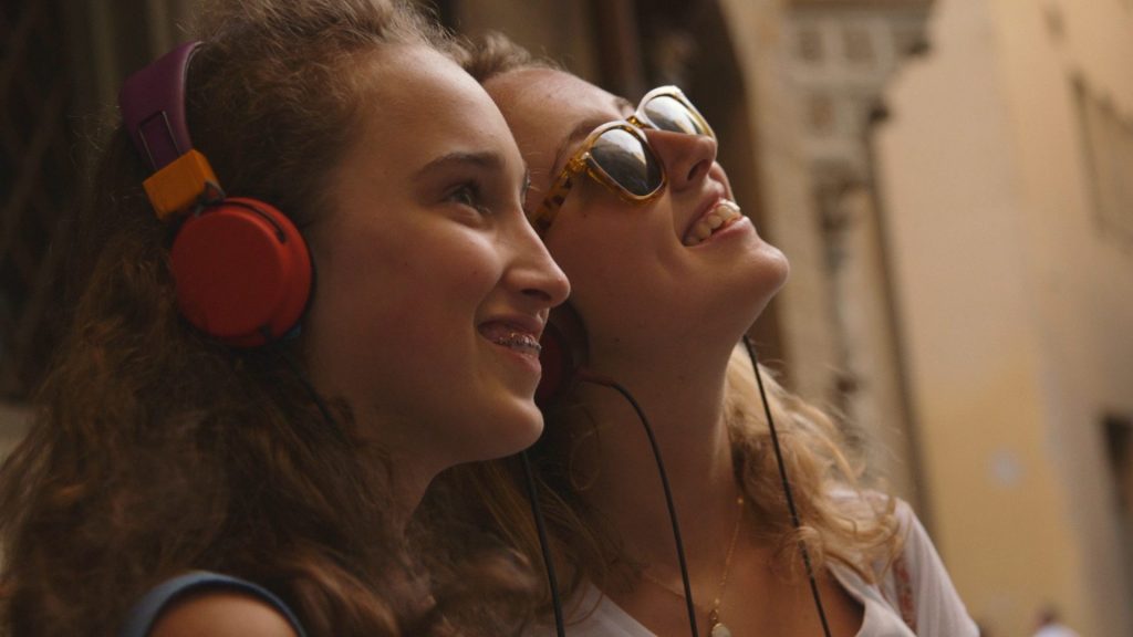 Film still of two girls using a tour app